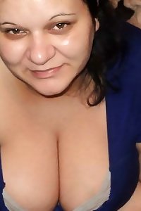 voluptuous plump woman smiles while vigorously fingering herself